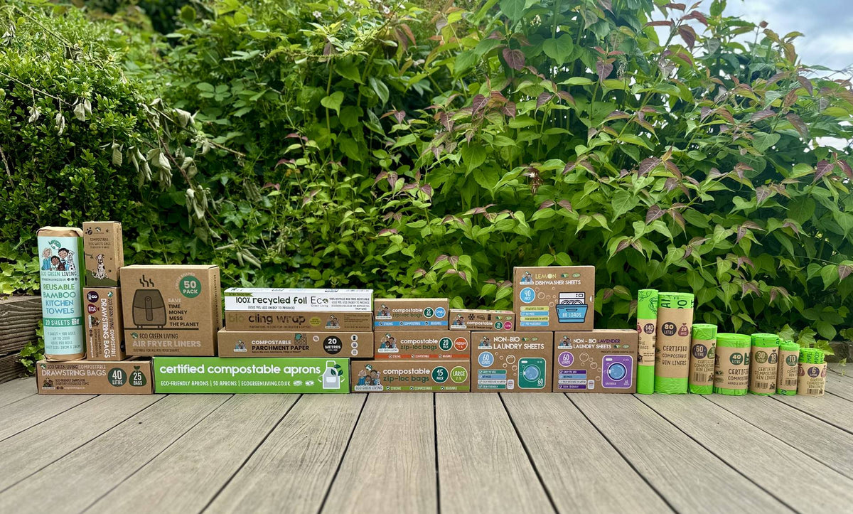 Compostable bin bags, cling wrap, recycled foil, laundry sheets and aprons lined up on a garden deck